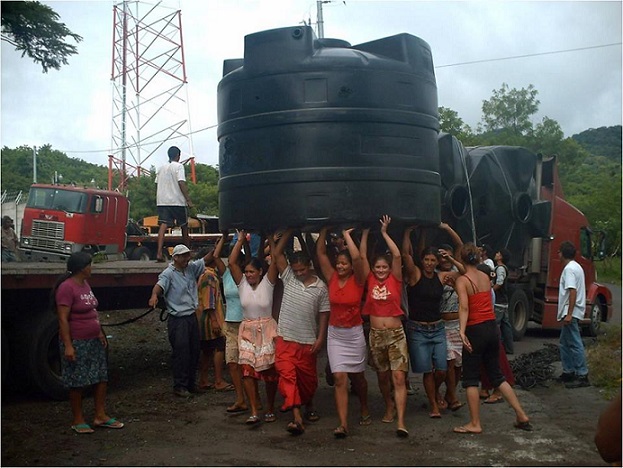 Habitantes beneficiados con el programa Techo y agua trabajan en conjunto para trasladar los captadores de agua. Foto FONAES